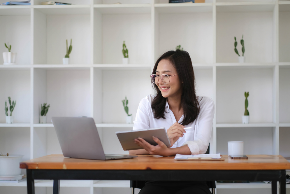 Woman smiling in front of a computer - How to Use HARO for SEO.