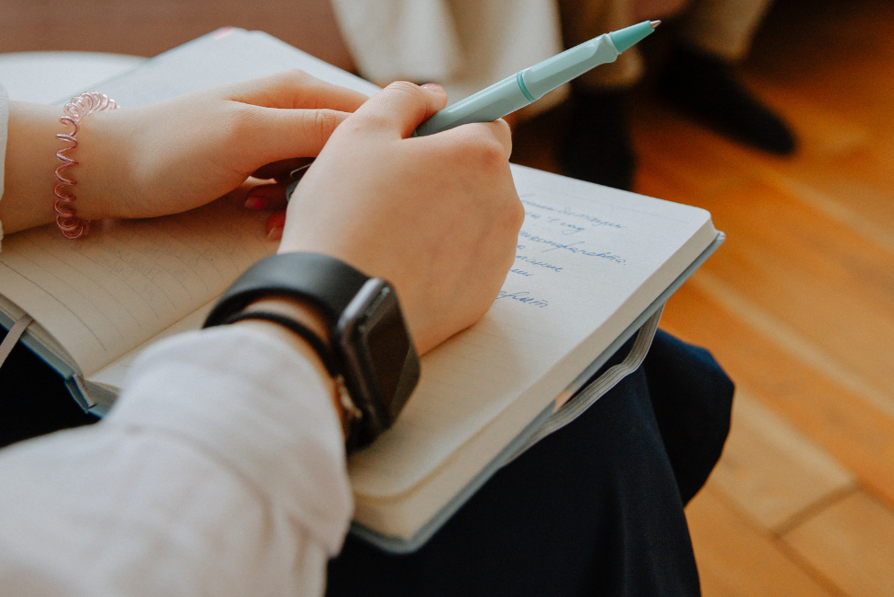 Woman holding a pen and a notebook - DAP notes