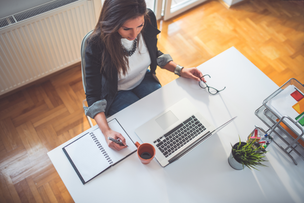 Woman taking notes while looking at her computer – The Private Practice Pro