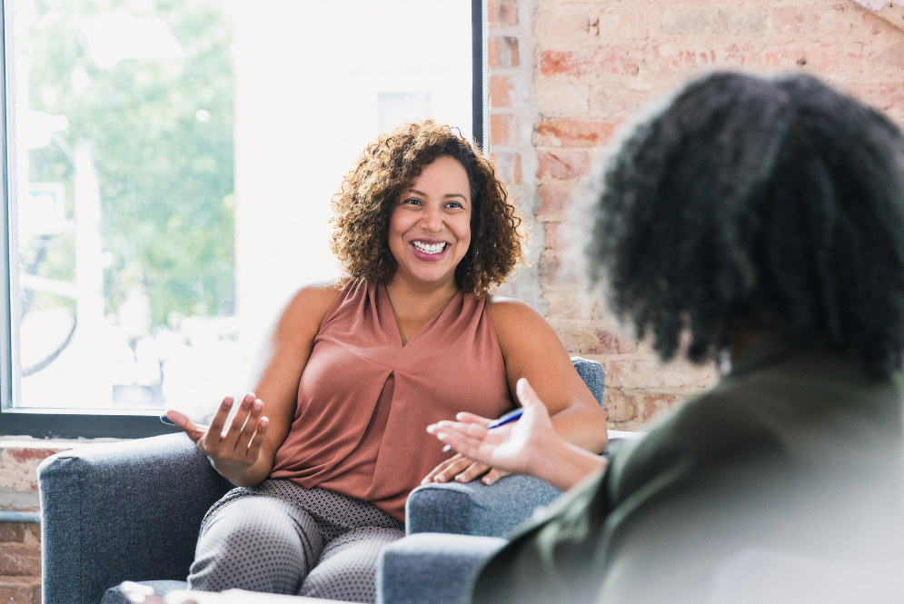 A therapist talking to a client inside an authentic therapy office - The Private Practice Pro